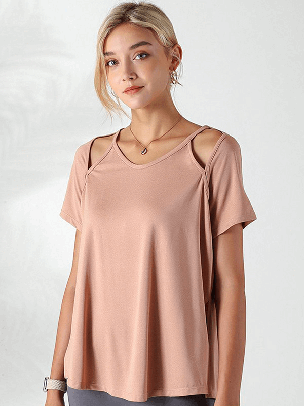 Woman wearing a pink loose hollow out shoulders t-shirt for running, showcasing breathable fabric, perfect for yoga and fitness activities.
